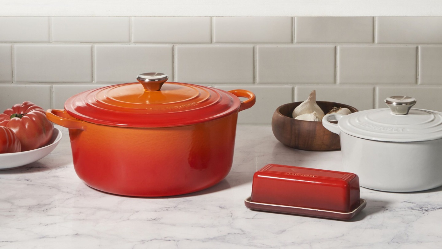 Orange og hvid gryde samt orange smørboks fra Le Creuset Outlet i Ringsted Designer Outlet
