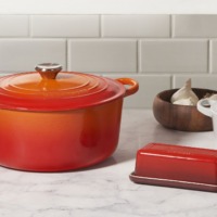 Orange og hvid gryde samt orange smørboks fra Le Creuset Outlet i Ringsted Designer Outlet