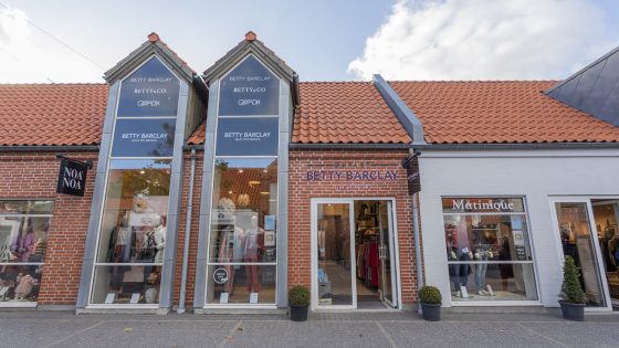 Kvinde iført tøj fra Betty Barclay - en kort beige jakke, bluse og bukser - et stilet look. Inspirationsbillede for Betty Barclay Outlet i Ringsted Designer Outlet, som sælger dametøj til outletpriser.