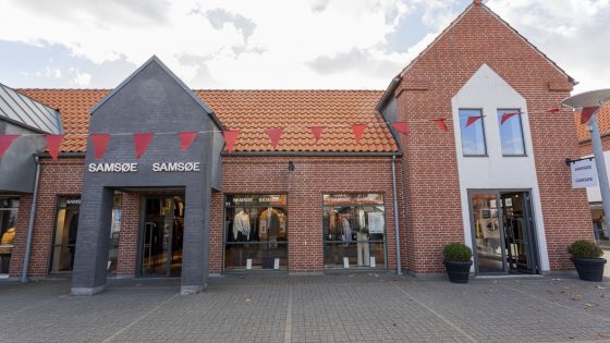 To modeller foran rød og hvid væg med Samsøe Samsøe branding – inspirationsbillede fra Samsøe Samsøe i Ringsted Designer Outlet