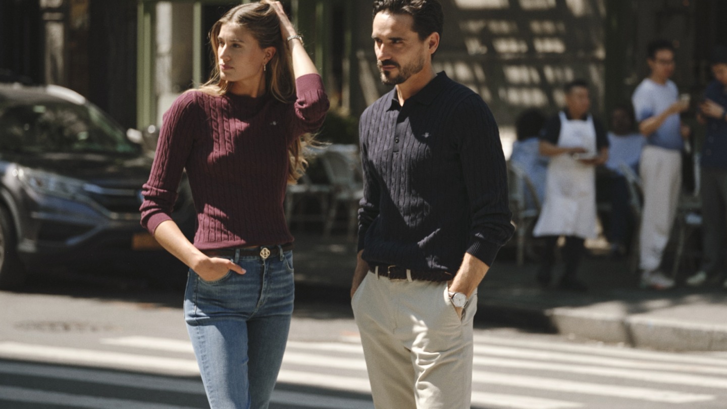 Dame iført bordeaux striktrøje og jeans og herre iført mørkeblå striktrøje og lyse bukser fra Gant - inspiration til shopping i Gant Outlet i Ringsted Designer Outlet.