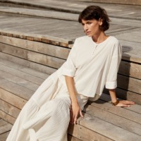 Kvinde i solen med lyst tøj fra Masai. Inspirationsbillede fra Masai som sælger mode til kvinder i Ringsted Designer Outlet.