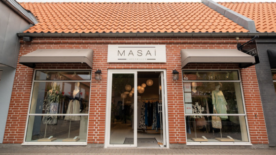 Kvinde i solen med lyst tøj fra Masai. Inspirationsbillede fra Masai som sælger mode til kvinder i Ringsted Designer Outlet.