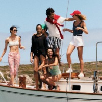 Modeller iført klassisk sommerligt Tommy Hilfiger-outfit på en båd – topbanner på Tommy Hilfiger outlets brandside hos Ringsted Designer Outlet
