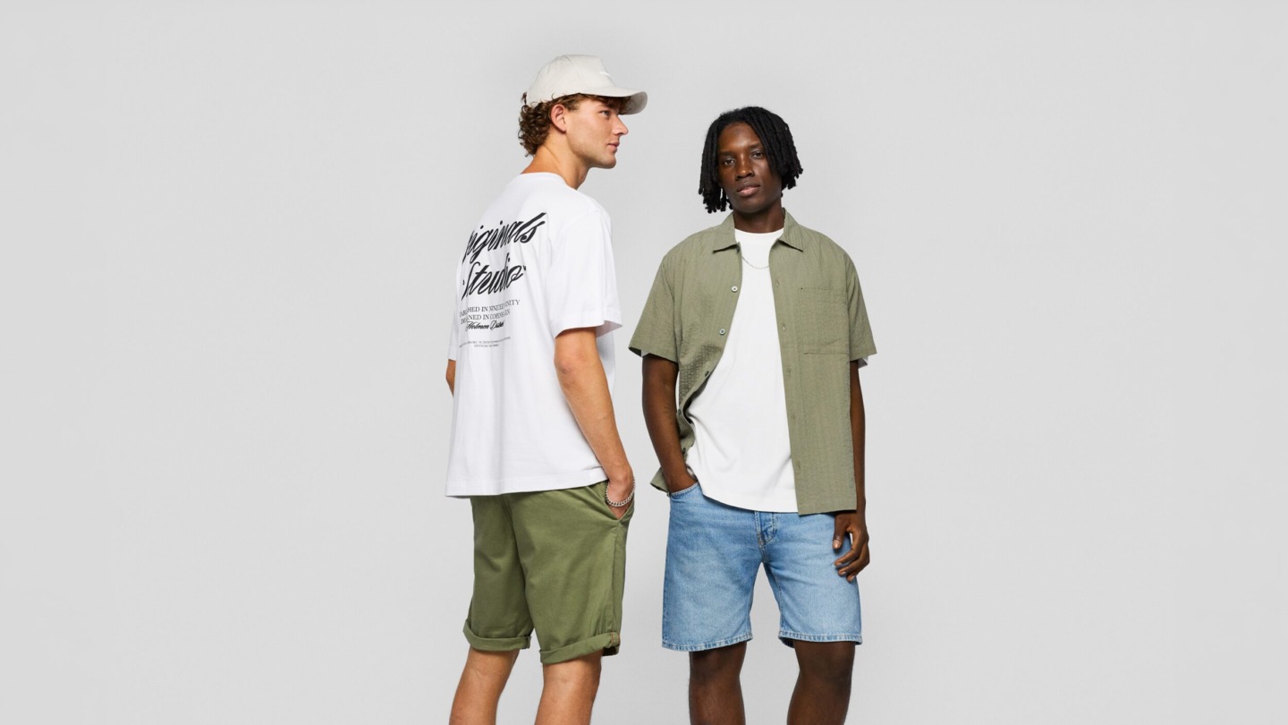 To mænd i tøj fra Jack & Jones - klassisk t-shirts, denim shorts, kortærmet skjorte som kan købes i Jack & Jones i Ringsted Designer Outlet