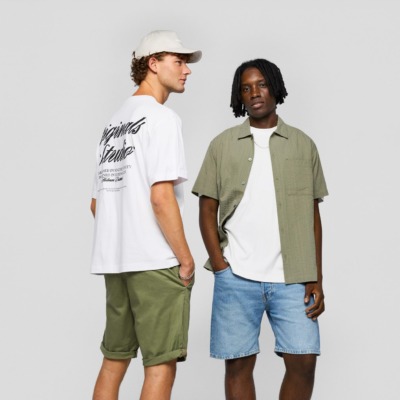 To mænd i tøj fra Jack & Jones - klassisk t-shirts, denim shorts, kortærmet skjorte som kan købes i Jack & Jones i Ringsted Designer Outlet